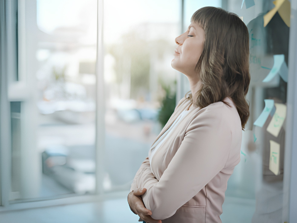 Vrouw met stress en burn-outklachten staat aarzelend voor een kantoordeur